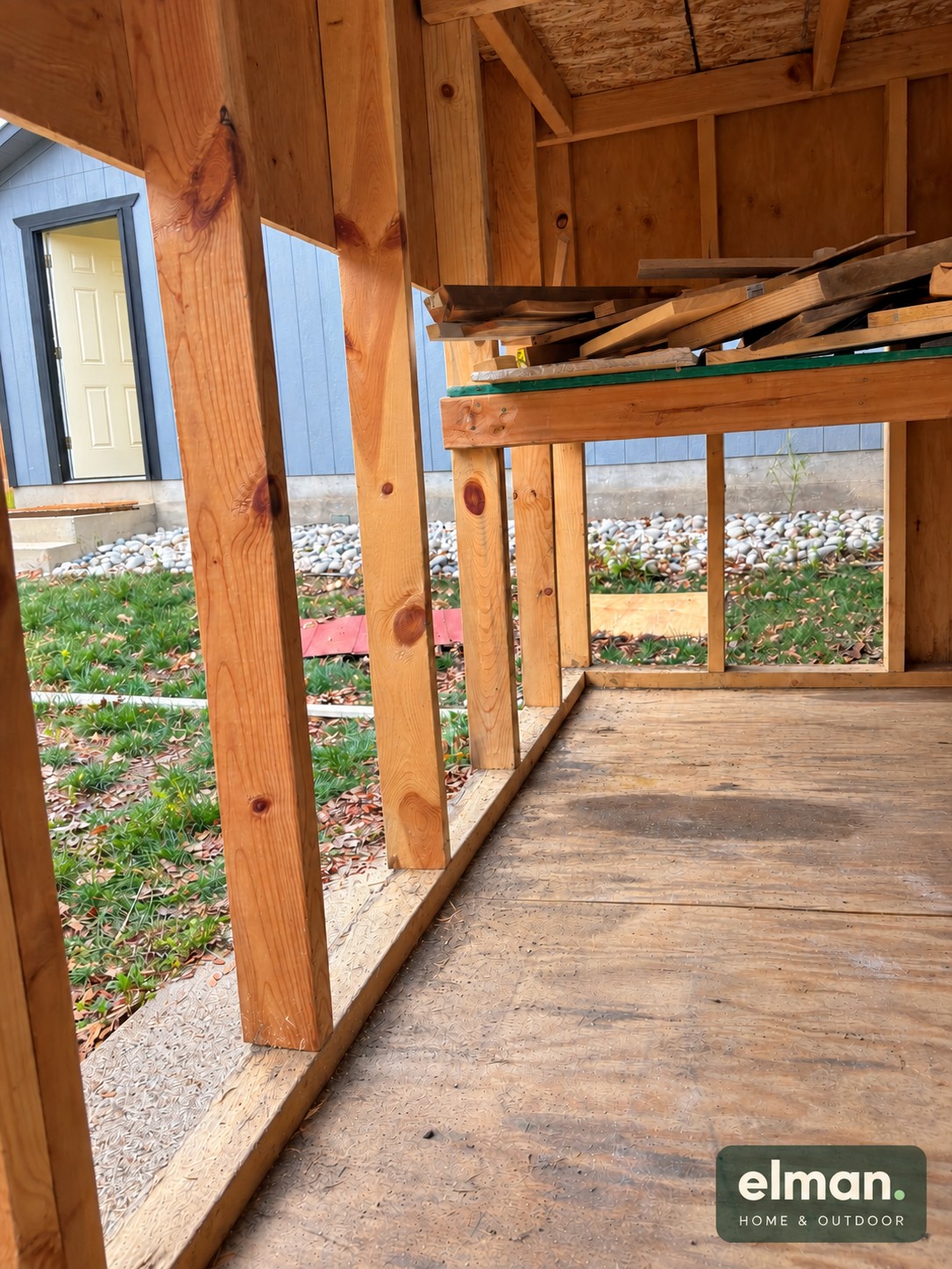 Inside the shed during repair, with damaged lower siding removed and wood framing visible